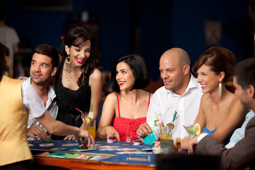 laughing friends playing cards in a casino